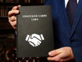 CONCEALED CARRY LAWS book in the hands of a lawyer. Concealed carryÃÂ is legal in most jurisdictions of the United States Royalty Free Stock Photo